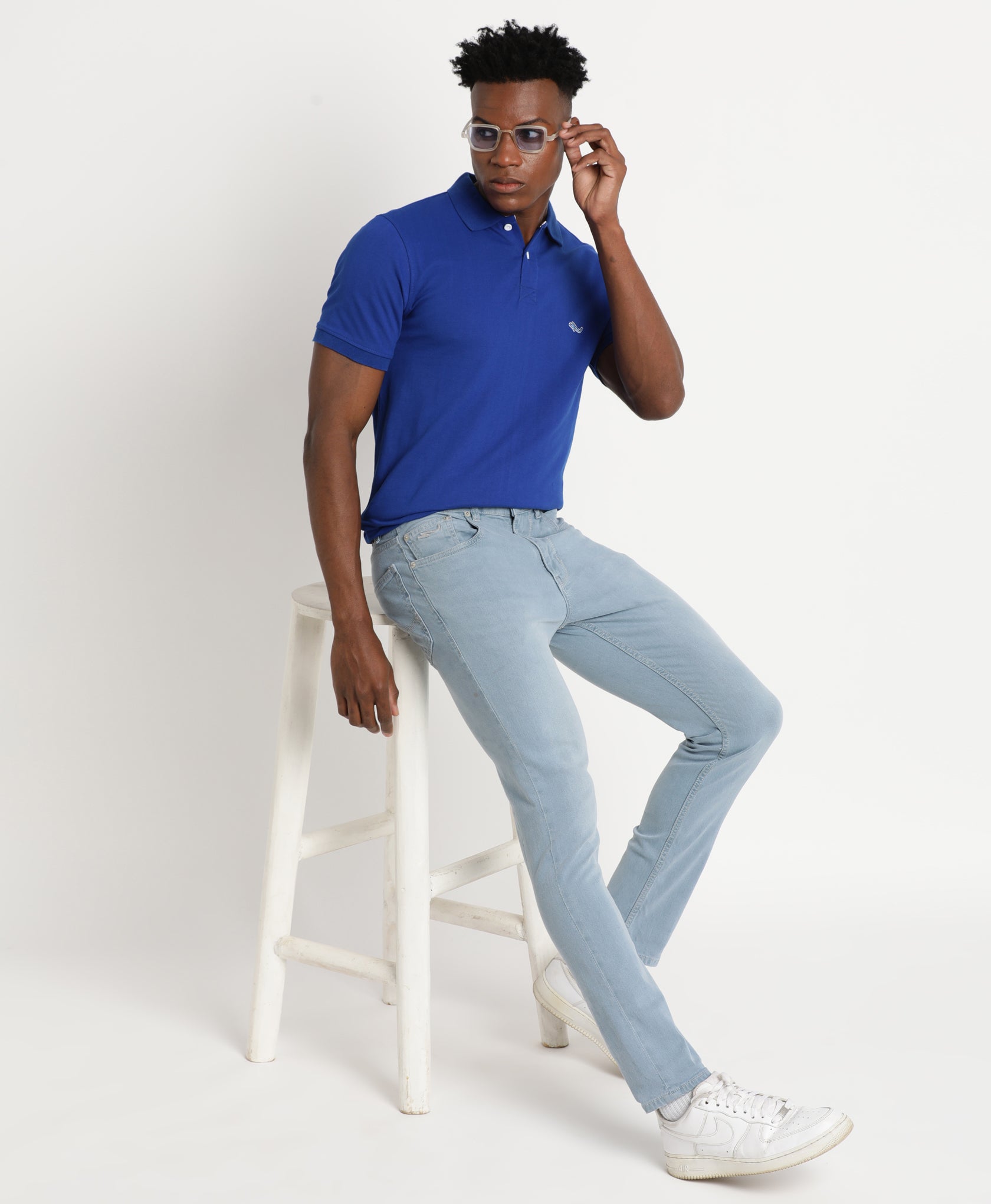 Premium Photo | A man in a white t - shirt and light blue jeans stands on a  street.